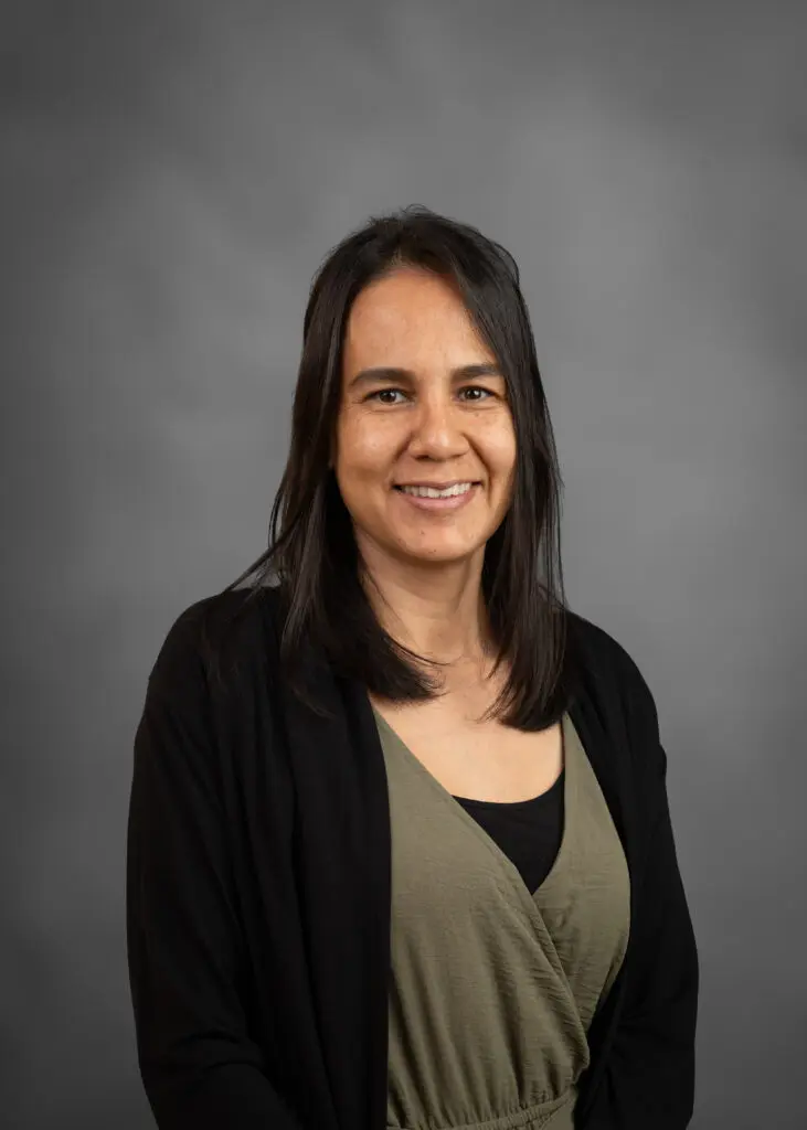 Woman smiling against gray background
