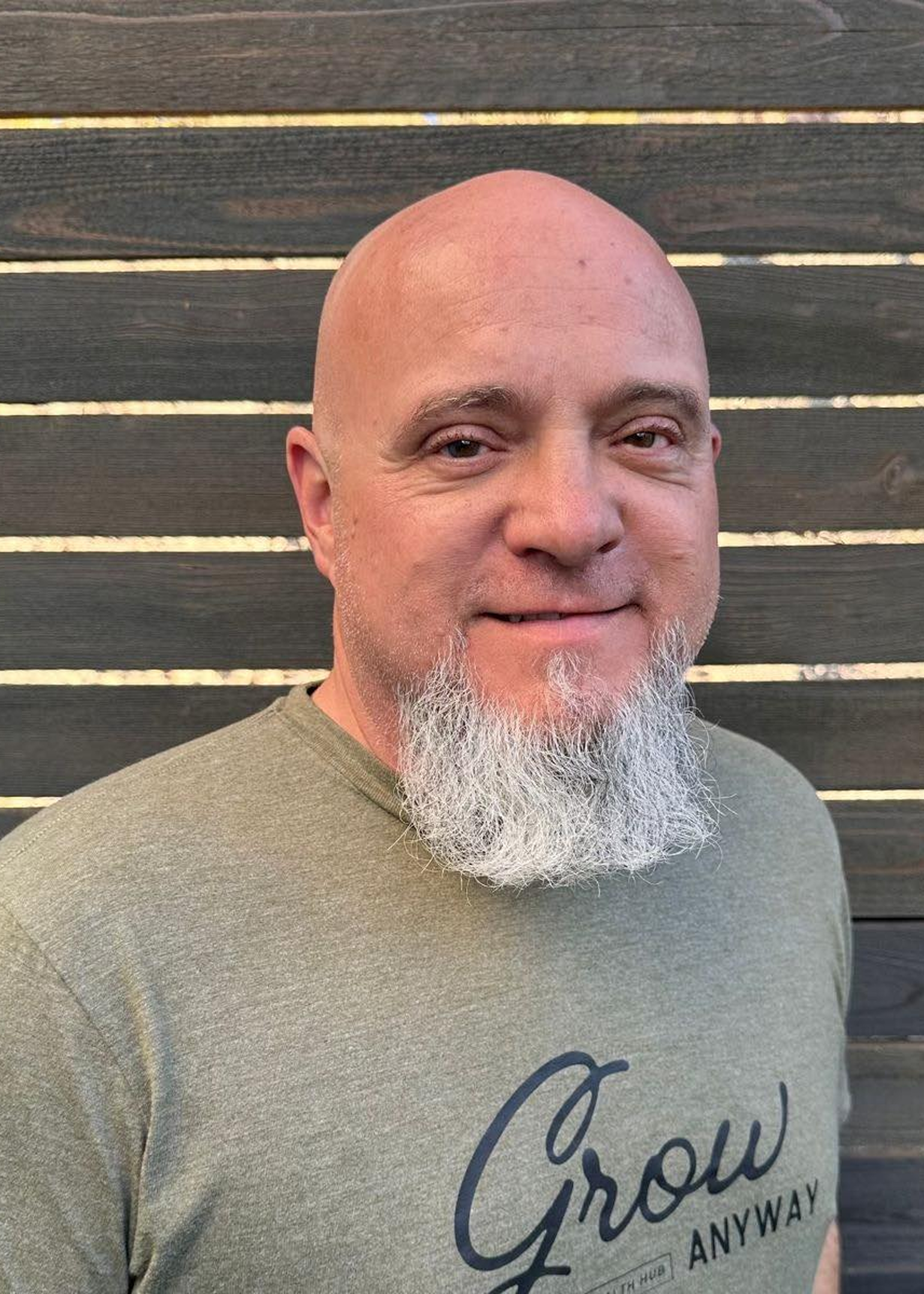 Man with a gray beard wearing a green T-shirt.