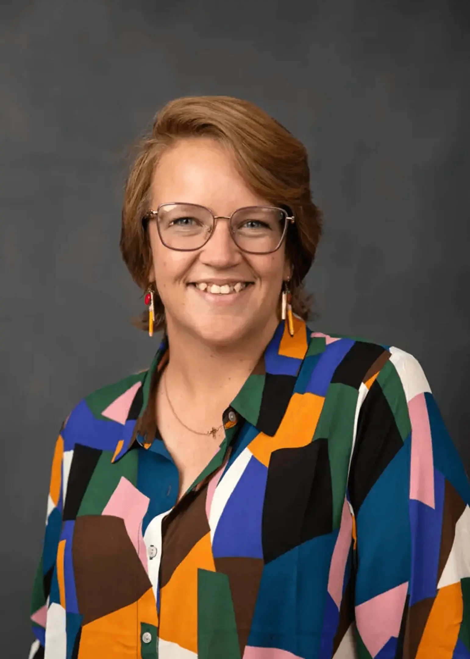 Smiling person in colorful geometric shirt
