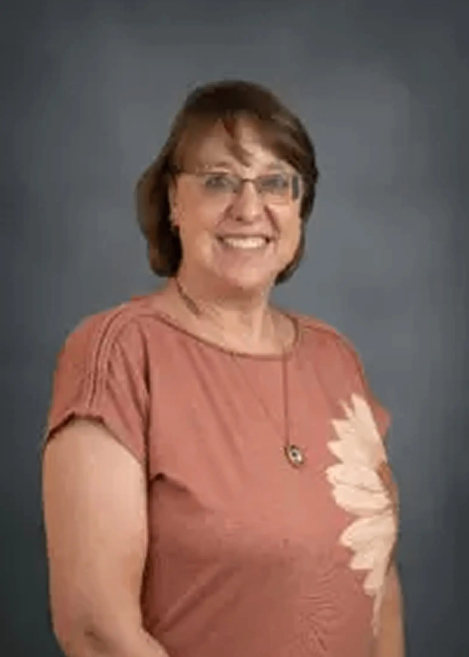 Smiling woman in glasses and floral shirt
