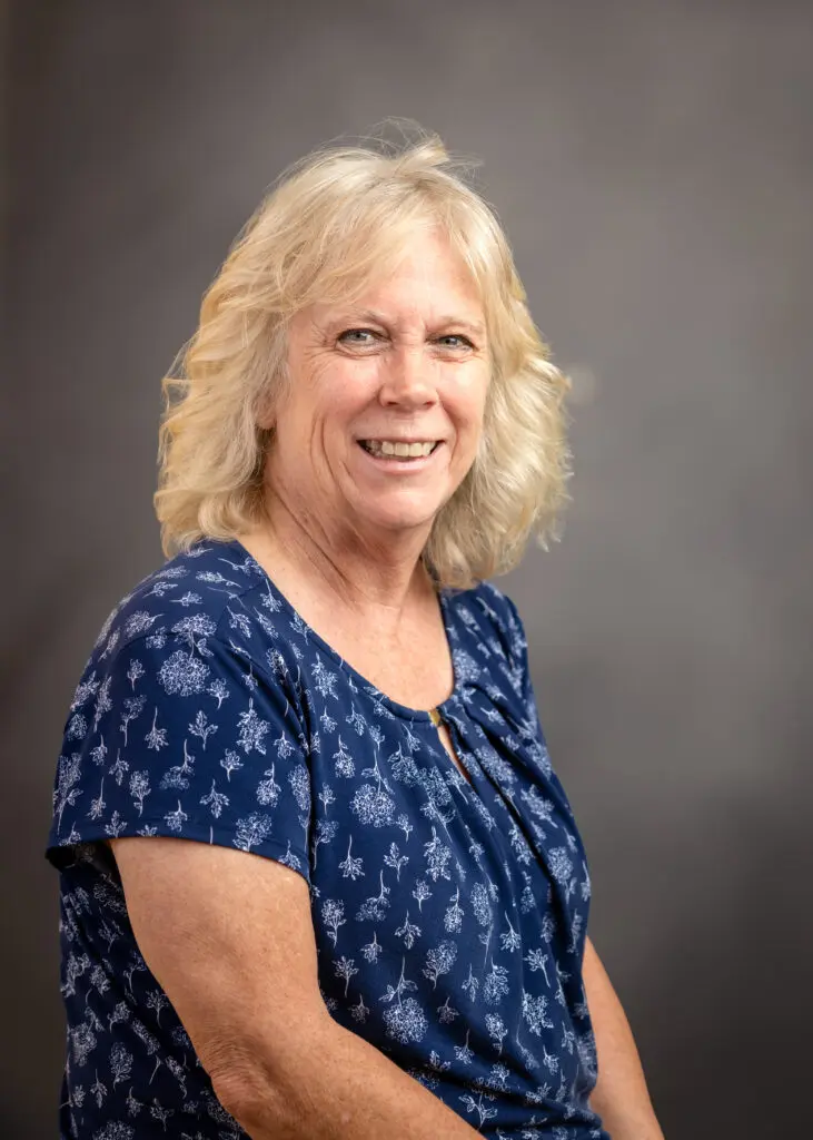 Smiling woman in blue patterned blouse
